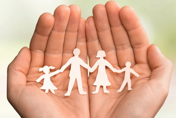 Hands holding paper cut out of family